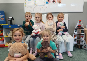 Dzieci pozują do zdjęcia ze swoimi pluszowymi misiami