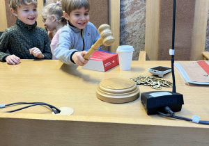 Chłopiec uderza młotkiem sędziowskim