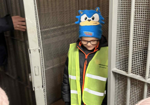 Chłopiec w drzwiach celi podczas zwiedzania aresztu śledczego