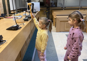 Dziewczynka uderza młotkiem sędziowskim