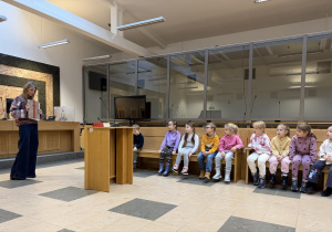 Pani Sędzia prezentuje dzieciom jak wyglądają akta sprawy sądowej