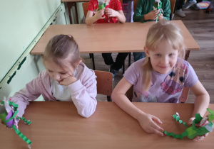 Dzieci siedzą w szkolnych ławkach