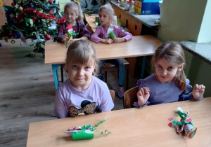 Dzieci siedzą w szkolnych ławkach