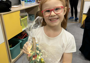 Dziewczynka pokazująca choinkę wykonaną z rodzicami