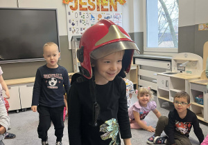 Chłopiec w kasku strażackim na głowie