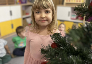Dziewczynka pozująca przy choince w sali