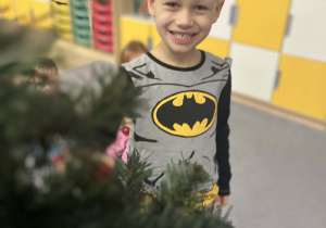 Chłopiec pozujący przy choince w sali