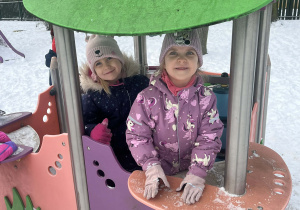 Dziewczynki uśmiechające się do zdjęcia podczas zabaw w ogrodzie przedszkolnym