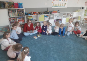 "Głośne Czytanie" - dzieci słuchają książki czytanej przez jednego z rodziców