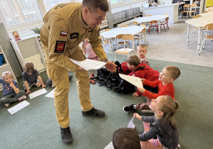 dzieci podczas zajęć edukacyjnych ze strażakiem