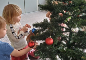 dzieci ubierają choinkę