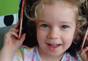 dziewczynka pozuje w kasku strażaka