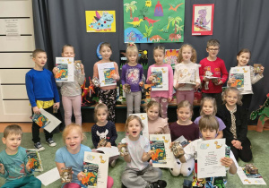 Dzieci z Grupy Sówek pozują do zdjęcia z nagrodami za udział w konkursie