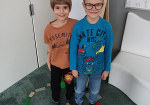 Chłopcy stoją w kole zbudowanym z klocków LEGO