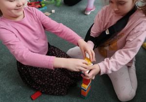 Dziewczynki budują wieżę z klocków LEGO