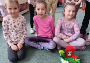 Dziewczynki prezentują dom zbudowany z klocków LEGO