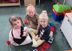 Dziewczynki siedzą w kole zbudowanym z klocków LEGO