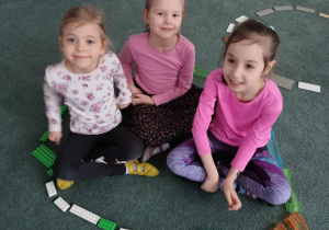 Dziewczynki siedzą w kole zbudowanym z klocków LEGO
