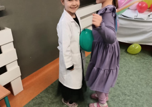 Dziewczynki tańczą z balonem trzymając go między brzuchami