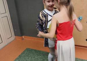 Dziewczynki tańczą z balonem trzymając go między brzuchami