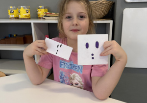 dzieci przy stołach odtwarzają tropy zwierząt z plasteliny