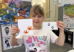 dzieci przy stołach odtwarzają tropy zwierząt z plasteliny