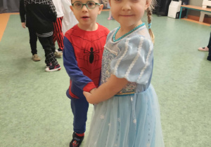 Dziewczynka przebrana za księżniczkę oraz chłopiec przebrany za spiderman'a podczas balu na sali gimnastycznej