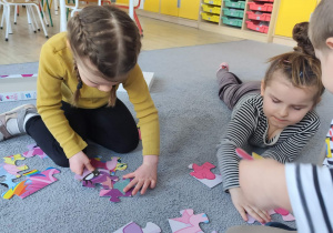 Dzieci układające puzzle na dywanie