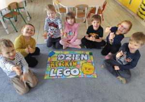 Dzieci na dywanie - zdjęcie grupowe z napisem Dzień Lego