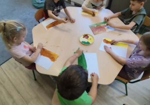 Praca plastyczna wykonywana przy stolikach z użyciem farb