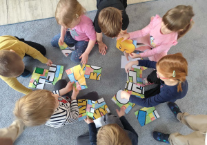 Dzieci układające puzzle na dywanie