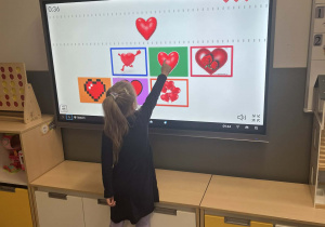 Dziewczynka rozwiązująca zagadkę na tablicy interaktywnej