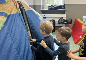 Dzieci wchodzące do balona imitującego ziemię - mobilne planetarium