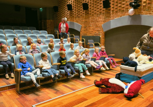 Dzieci siedzą w sali kinowej