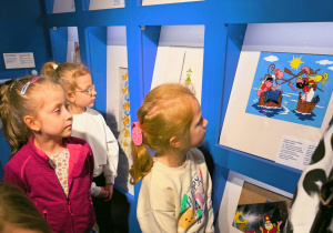 Dziewczynki oglądają na ścianach ilustracje