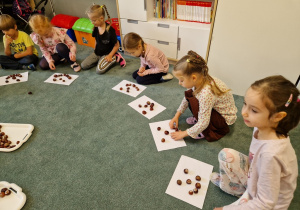 dzieci układają buzie z kasztanów