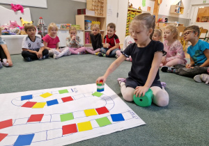 dziewczynka przesuwa pionek na grze planszowej