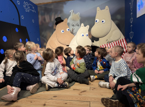 dzieci na tle wystawy Muminki w muzeum kinematografii