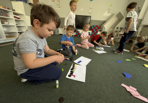 dzieci wyklejają lokomotywę z figur geometrycznych- nawiązanie do twórczości J. Tuwima