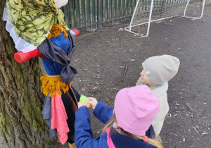 Dzieci w ogrodzie polewające marzannę wodą