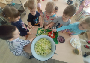 Dzieci wykonujące sałatkę grecką