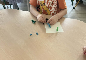 Chłopiec wylepiający z plasteliny przy stoliku