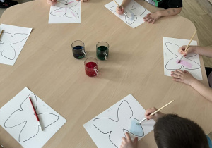 Dzieci malujące motyle farbami wykonanymi z bibuły