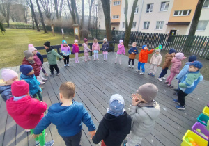 Dzieci w kole na scenie w ogrodzie przedszkolnym