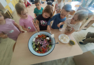 Dzieci wykonujące sałatkę grecką
