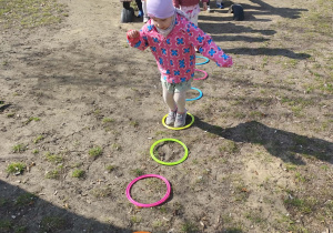 Dzieci pokonujące tor przeszkód w ogrodzie