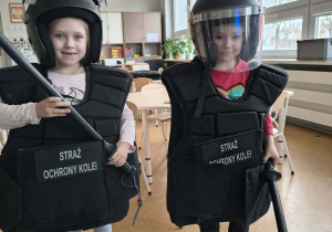 Dzieci ubrane w kamizelki i hełmy Straży Ochrony Kolei