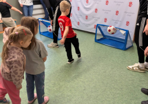 Chłopiec strzelający gola do bramki