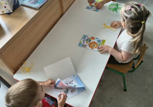 Dzieci oglądają upominki otrzymane od solenizantki