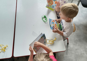Dzieci oglądają upominki otrzymane od solenizantki